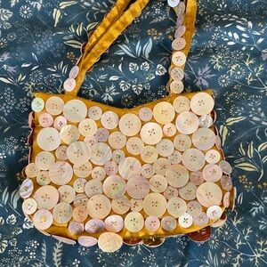 Mother-of-pearl button bag in gold satin.